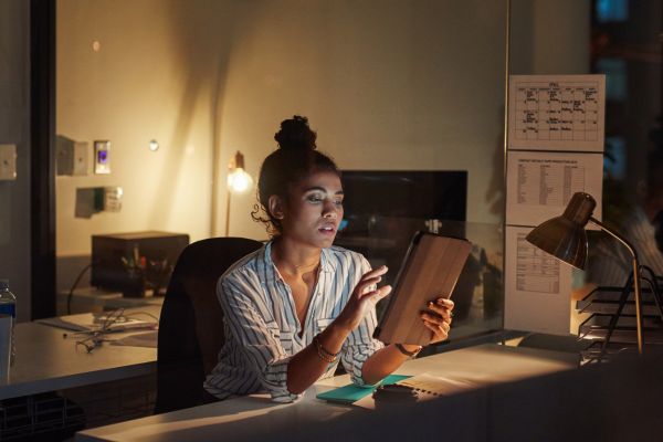 Lady working by herself at night in an office and looking pleasant and peaceful