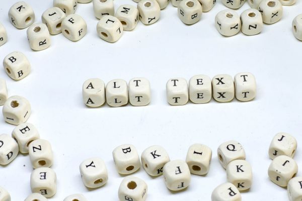 Photo of letter dice scattered around with ALT TEXT spelled out of dice in the center